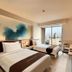 Midtown Hotel Surabaya guest room with twin beds and city view through large window