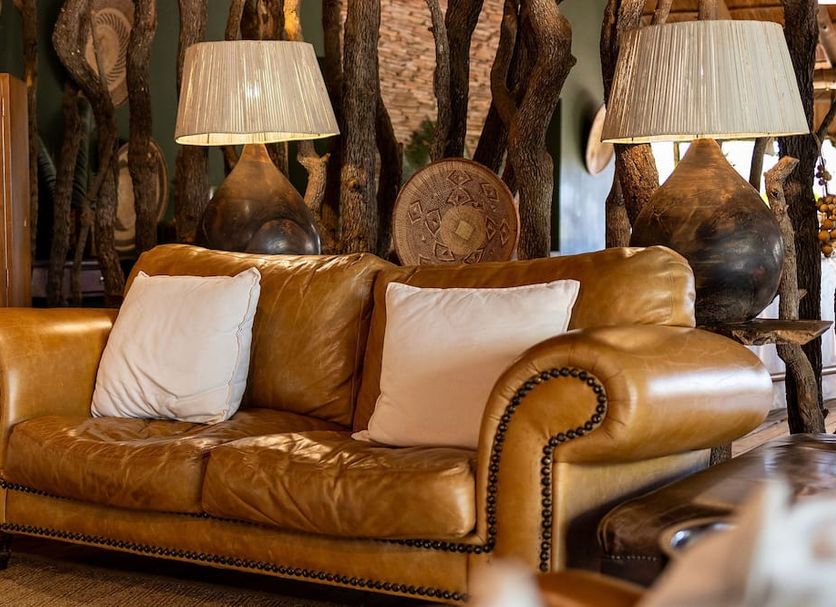 Karongwe - Chisomo Safari Camp in Metz: leather sofa with lamps in a cozy lounge