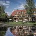 Hotel Strandhaus - Boutique Resort & Spa in Lübben with riverside lawn, terrace, and reflected façade