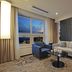 Airsky Hotel Incheon in Incheon guest room with sofa, armchair, bed, and city-and-sea view