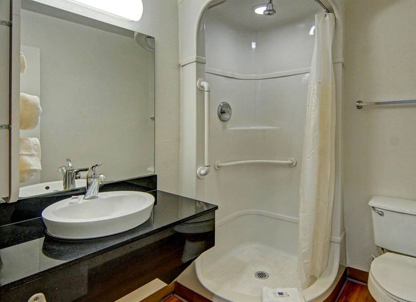 Motel 6 Longview, TX bathroom with walk-in shower, vanity sink, and toilet