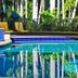 Kununurra Country Club Resort in Kununurra, poolside loungers beside a blue-tiled outdoor pool and palm trees