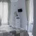 Sfumature Partenopee Naples guest room with white bed, sheer curtains, wall TV and balcony doors