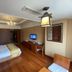 Jinjun Hotel Chongqing guest room with bed, wood floor, desk and wall-mounted TV