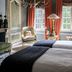 B&B The Verhaegen Ghent guest room with chandelier, tall windows, armchair and twin beds