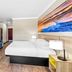 Days Inn by Wyndham Rockdale Texas guest room with king bed, TV console, and landscape wall art