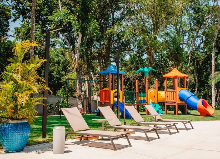 Sanma Hotel in Foz do Iguaçu with poolside loungers and a colorful children's playground