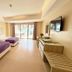 The Muse Beach Front Hotel Boracay room with two beds, sliding doors to balcony, and TV in Boracay