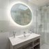 Center Parcs De Vossemeren bathroom with round backlit mirror, vanity sink and glass shower in Lommel