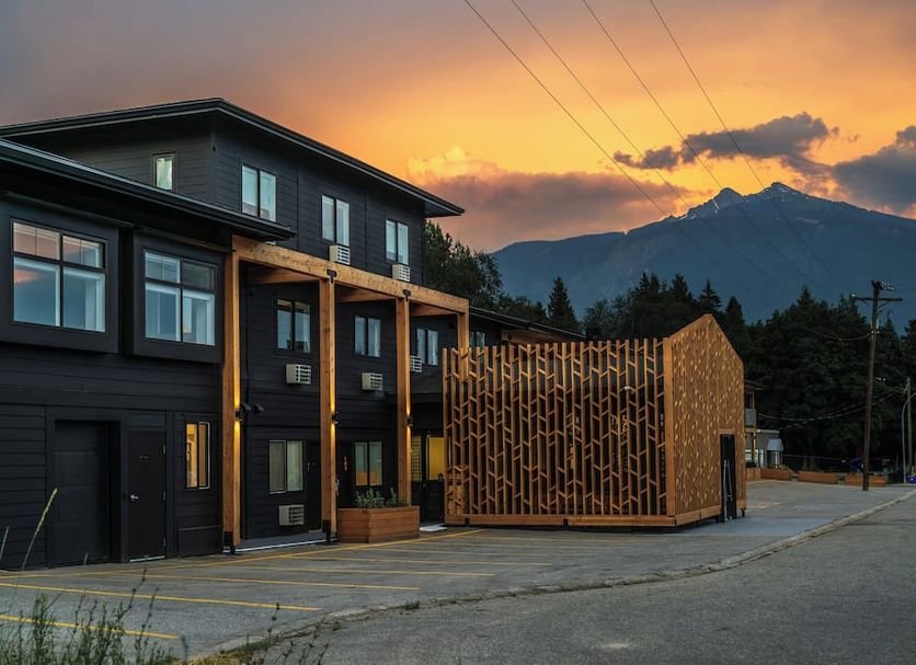 Gravity Haus Revelstoke hotel exterior at sunset with mountain backdrop in Revelstoke