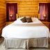 Beartooth Hideaway Inn & Cabins in Red Lodge, log cabin guest room with king bed and bedside lamps