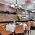 Beifang Langyue Hotel (Beijing Ganjiakou) restaurant with round tables, brick wall and chandeliers in Beijing