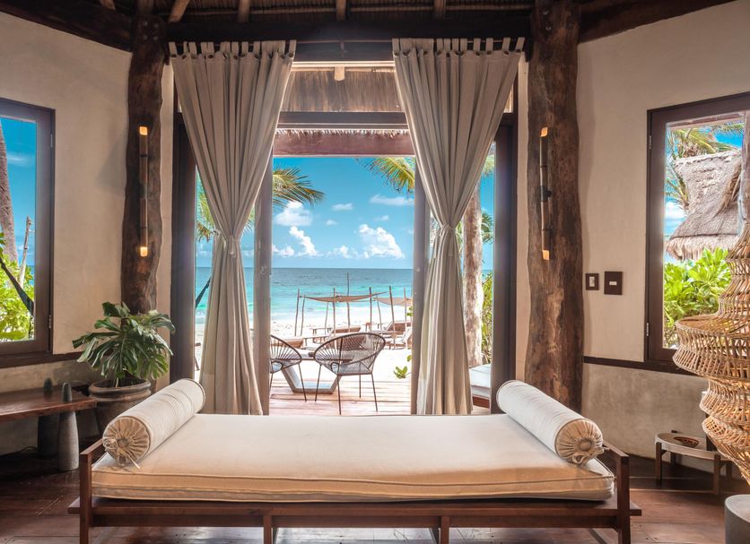 Delek Tulum in Tulum with a beachfront cabana bed and ocean view through open curtains