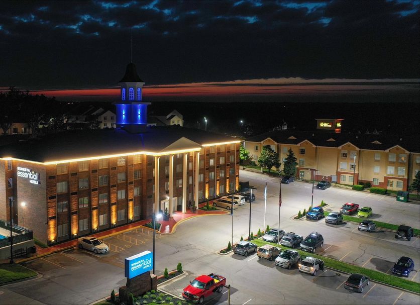 Night view of Sonesta Essential Hotels Overland Park with lit exterior, parking lot, and pool