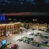 Night view of Sonesta Essential Hotels Overland Park with lit exterior, parking lot, and pool