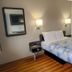 Motel 6 Dayton. Oh guest room with double bed, wall-mounted lights, mirror and wood-look flooring