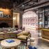 Moxy Cincinnati Downtown lobby with brick fireplace, lounge seating, and arched patterned wall in Cincinnati