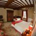 La Ferme de la Gronde, Bayeux: rustic guest room with twin beds, exposed beams, wardrobe and tiled floor