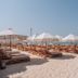 Umm Al Quwain Beach Hotel beach with loungers, umbrellas and turquoise sea in Umm Al Qaiwain