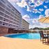 Golden Tulip Kumasi City in Kumasi: outdoor pool with patio table, umbrella and hotel building