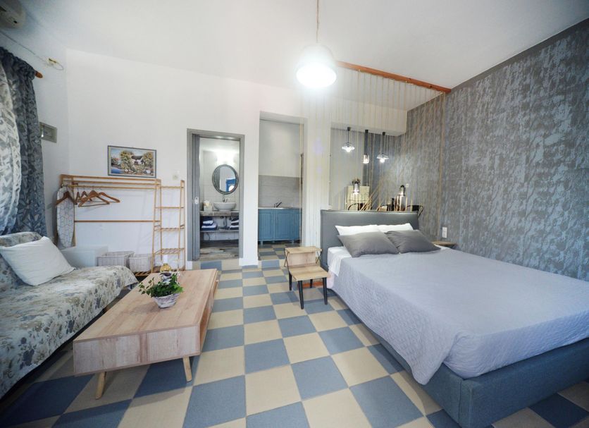 Panorama Studios & Apartments in Mirties, guest room with bed, sofa, coffee table, and checkered floor