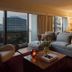 Sixty Beverly Hills suite with sofa, city-view windows, and warm lamp-lit living area