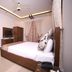 Zifan Hotel & Suites in Karachi room with a double bed, wardrobe, wall TV and ceiling fan