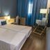 Hotel Santiago, Praia: twin beds in a guest room with blue curtains, desk, and chair