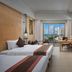 Sanya Bay Asgard Seaview Hotel in Sanya guest room with twin beds, balcony, and ocean view