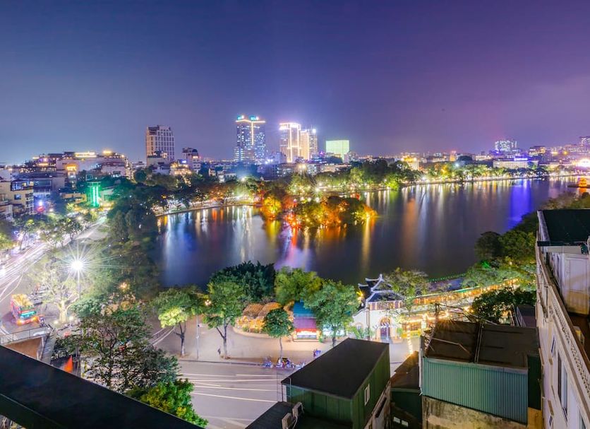 Hanoi Morning Hotel in Hanoi with a night city lake view and lights reflecting on the water