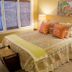 Fairfield Manor Bed and Breakfast in Shreveport bedroom with floral bedspread, bedside lamps and artwork