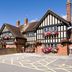 Premier Inn Christchurch - East in Christchurch, Tudor-style hotel exterior with flower baskets and parking area