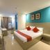 Legazpi Tourist Inn, Legazpi City room with bed, wall-mounted TV, desk, and teal accent wall