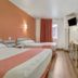 Motel 6 Roseburg guest room with two beds, wall lights, desk, and window with curtain