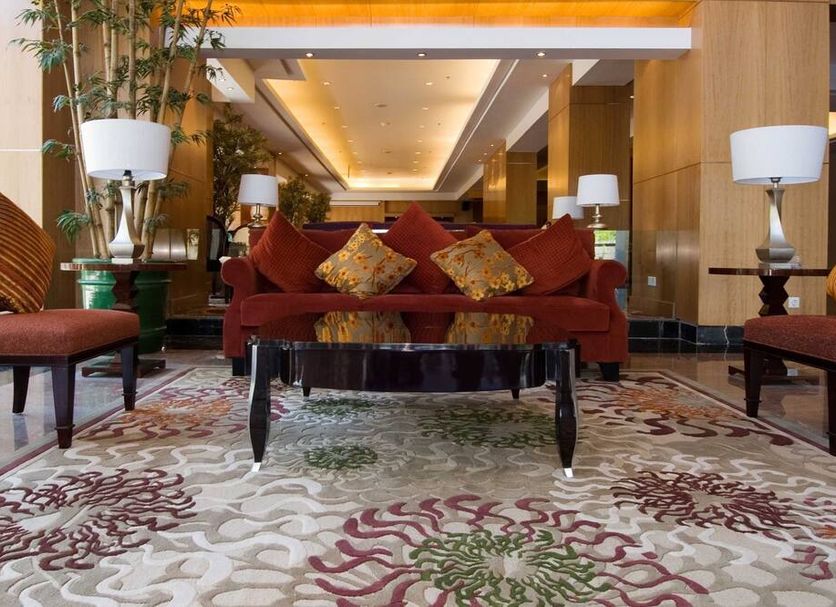 Aston Manado Hotel lobby seating area with red sofa, patterned rug and table lamps in Manado