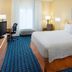 Fairfield Inn & Suites by Marriott Lafayette guest room with king bed, desk, and window seating