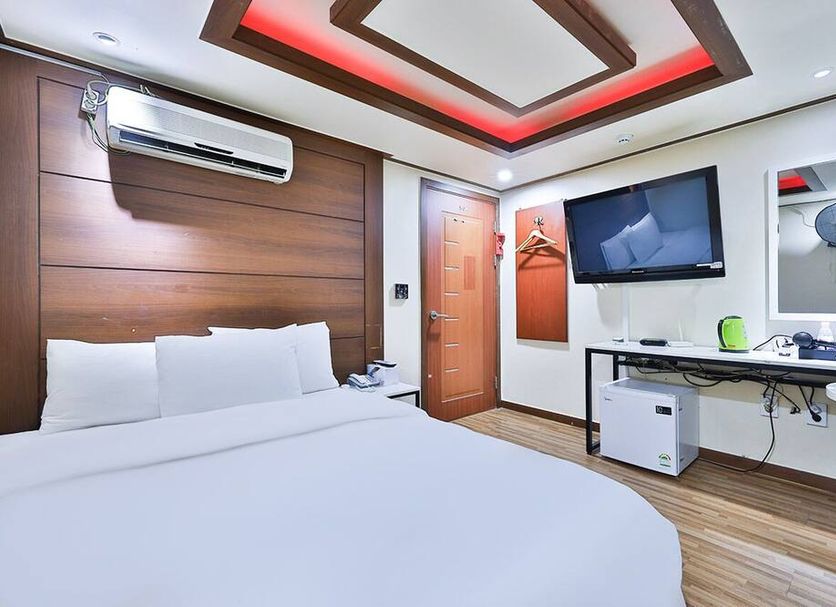 Picasso Motel Seoul guest room with bed, wall-mounted TV, desk, and air conditioner