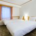 Toyoko Inn Gumma Isesaki Ekimae guest room with two twin beds and window with curtains in Isesaki