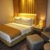 Orchardz Hotel Industri Jakarta guest room with queen bed, armchair, ottoman and bedside lamp