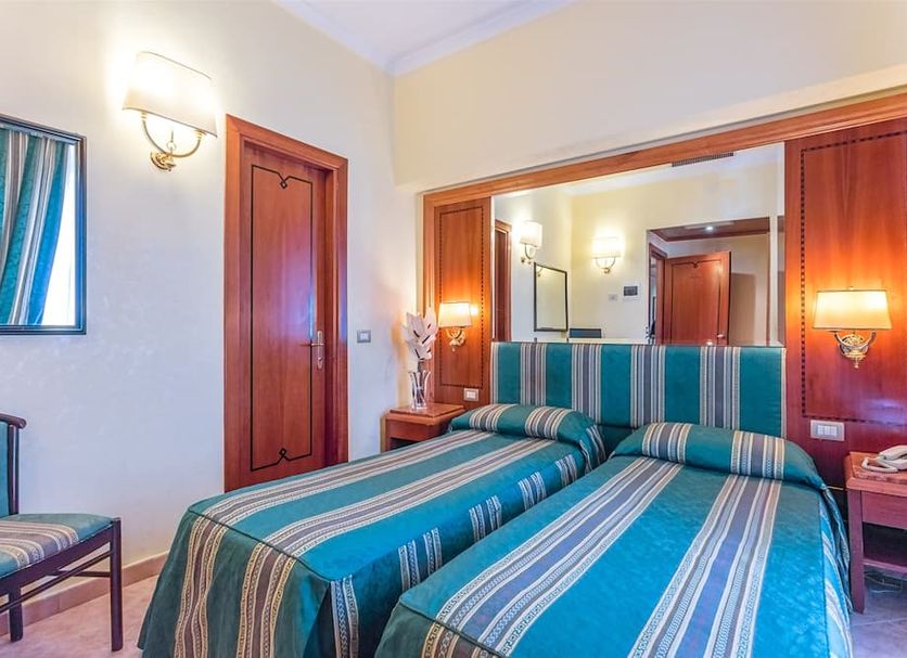 Raeli Hotel Lazio Rome guest room with two twin beds and striped blue-green bedding