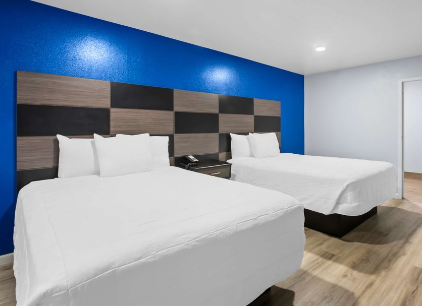 Americas Best Value Inn Gonzales room with two double beds and blue accent wall