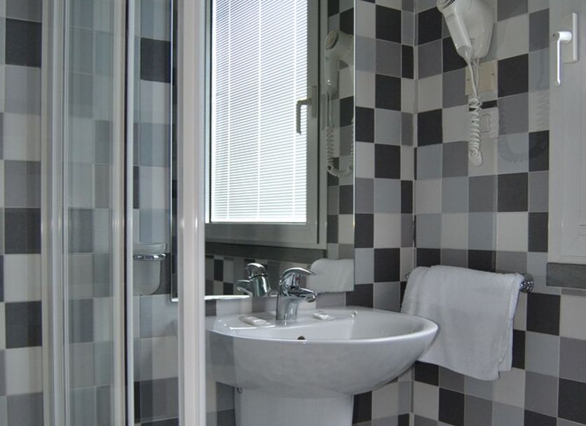 Hotel I' Fiorino in Capraia Fiorentina bathroom with checkered tile shower, sink and mirror