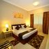 Emirates Stars Hotel Apartments Sharjah bedroom with king bed, nightstands, wardrobe and window drapes
