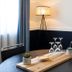 Hawkesbury Race Club Motel in Windsor room with round table, lamp, and tray of glassware