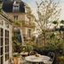 Château Voltaire in Paris courtyard with round bistro table, wrought-iron chairs, and Parisian façade