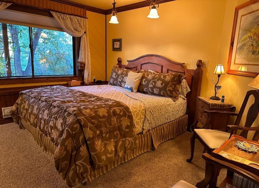 Country Sunshine Bed And Breakfast in Durango bedroom with a king bed, window view, and warm lighting