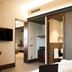 Gasometer Urban Suites Rome bathroom and bedroom with sliding door and TV
