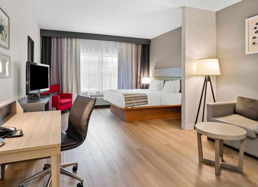 Country Inn & Suites by Radisson, Roanoke, VA guest room with bed, sitting area, desk and window view