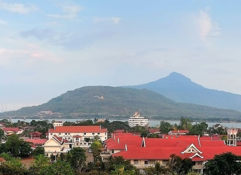 Pakse Hotel & Restaurant in Pakse with red-roofed cityscape and mountain backdrop