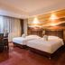 Wuyue Yuexin Hotel (Jinggangshan) room with two beds, dining table, and scenic wall mural in Ji'an